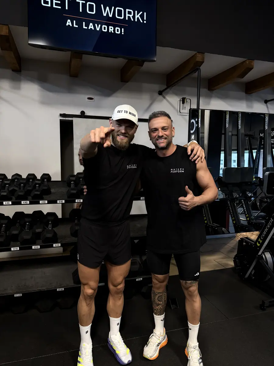 Hugo Hugemark con un partecipante davanti allo schermo GET TO WORK! AL LAVORO!