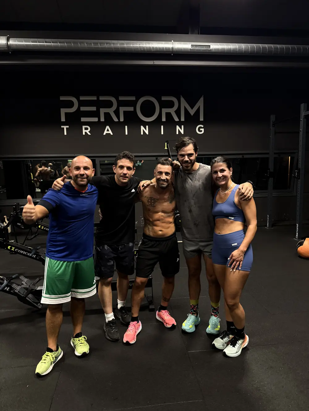 Cinque partecipanti sudati dopo l’allenamento, sotto la scritta Perform Training