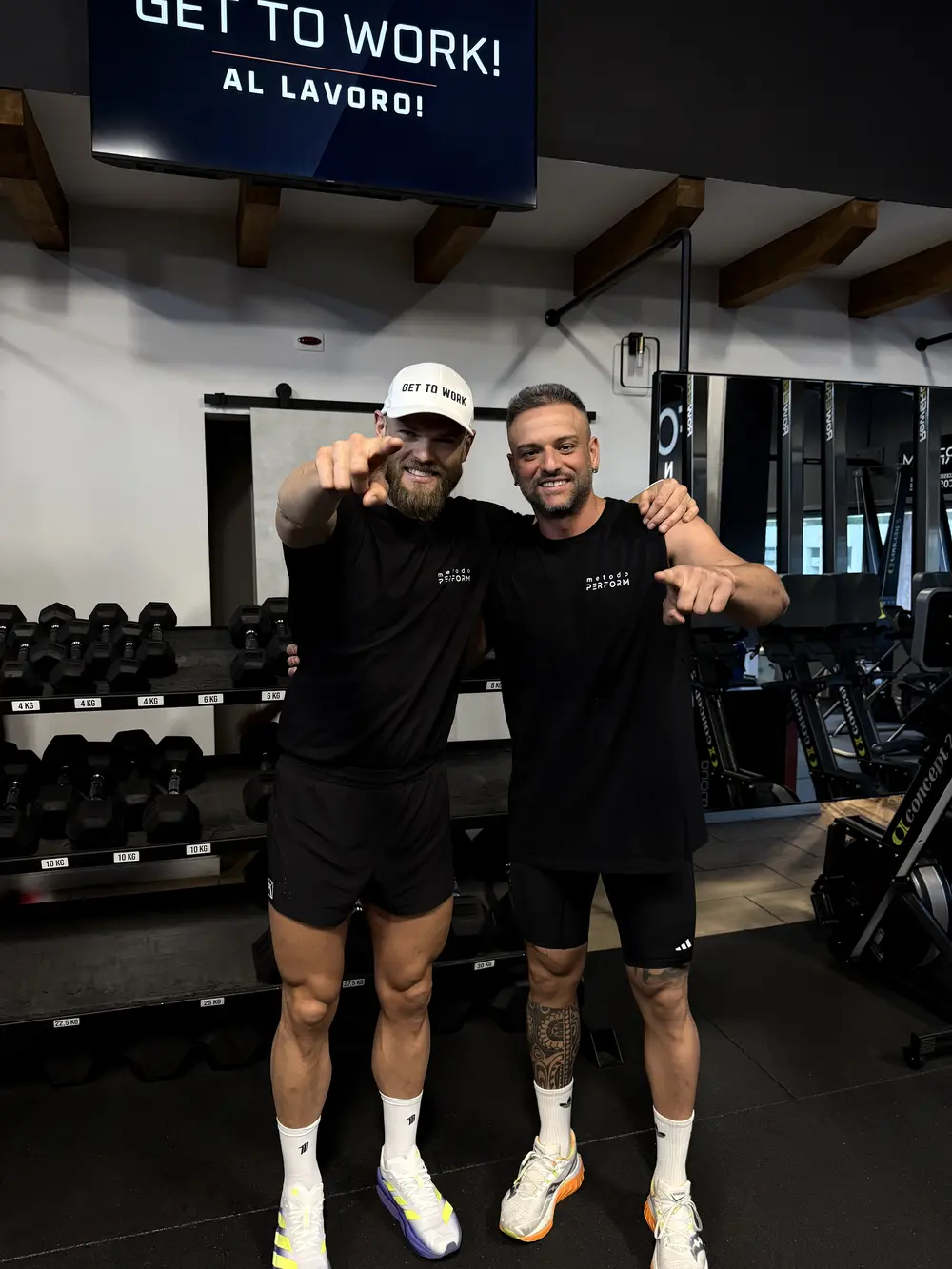 Hugo Hugemark e Pat davanti allo schermo con la scritta GET TO WORK! AL LAVORO!