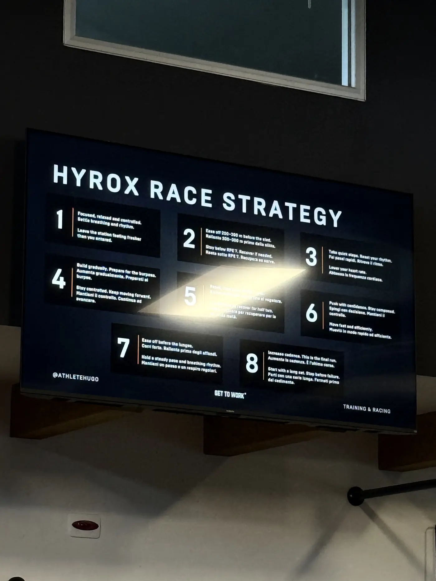 Lo schermo della sala con la slide HYROX Race Strategy, otto punti numerati